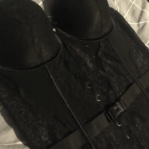 Spets korsett  - Världens snyggaste korsett 😍🖤 som tyvärr inte passar mig 😭 jag tror storleken är 75B på kuporna och runt midjan är det justerbart med knytning i ryggen (se bild 3) så passar (typ) alla!! den är helt oanvänd!! då de inte var min storlek :( hör av dig för mer info/om du undrar något mått! Frakt tillkommer, om flera är intressserade blir det budgivning 🖤