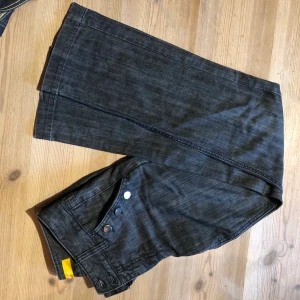 Jeans  - Mörkgrå lågmidjade jeans med knappar. Köpta på secondhand men aldrig använda 