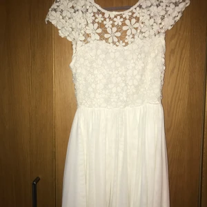 Vit klänning - Vit klänning från märket ”Exenia boutique” med superfina blommor och djup rygg. Storlek 6 skulle säga att den är xs/s. Jag är 173.
