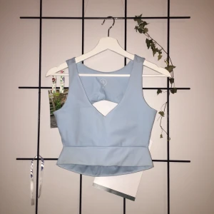 Pastellblå topp - Topp i Strechtyg. Ljusblå. Strl S. Öppen rygg. Säljes pga förliten vid bysten. Pris 100 kr. 