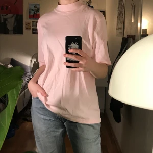 T-shirt  - Ljusrosa t-shirt med lite högre krage. Jättefin och skön, ganska lång. Köpt på second hand men i fint skick 