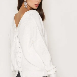  - Stickad tröja från NLY Trend. Ribbad tröja med V-ringning framtill. Snörning baktill. Knappt använd. Frakt +30kr