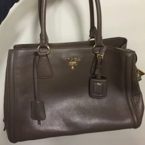  - En liknande mörk brun Prada väska, ej äkta! Köparen står för frakt på 100kr 