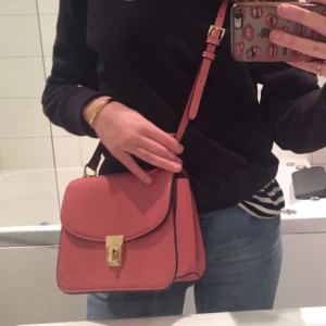  - Rosa crossbody väska i helt nyskick från Mango, ej fått användning då jag har för många väskor. Guldiga detaljer och fin ljusrosa färg. Justerbart band! Frakt på 45 kr tillkommer. 