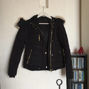  - Jätte snygg vinterjacka från Topshop i London. Ej använd mycket pga fel storlek. Väldigt mörkblå färg med guld knappar och dragkedjor. Kan dras åt längst ned och pälsen på luvan kan tas bort. 