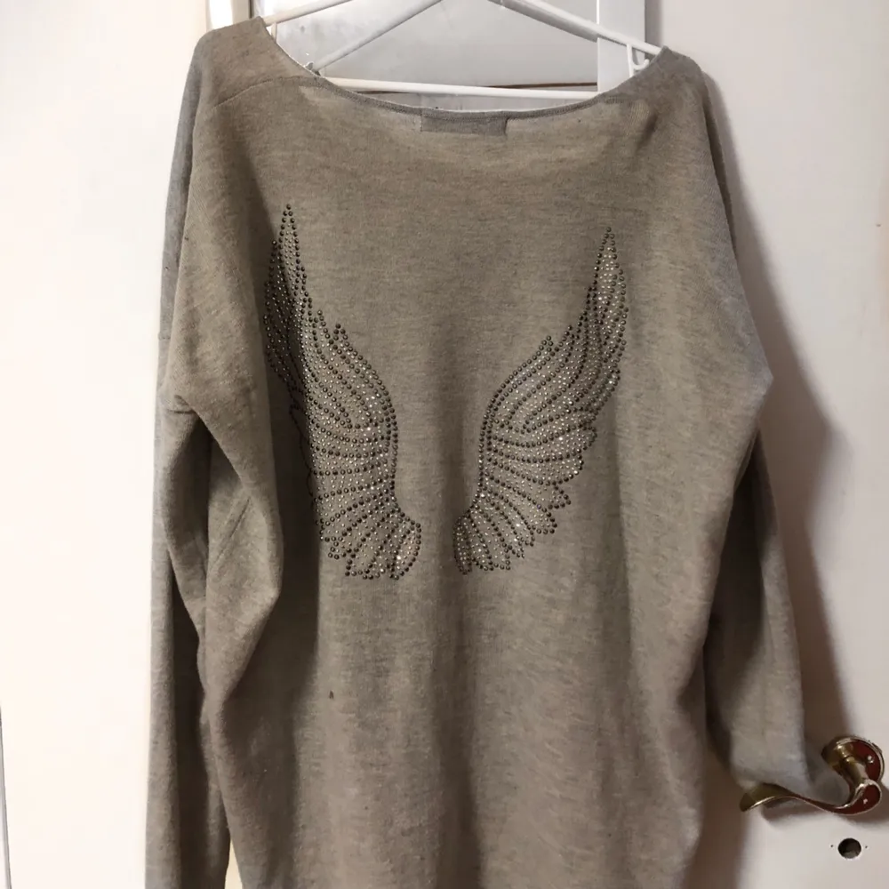 En stickad tröja med ängel vingar baktill. One size så passar allt från XS-L skulle jag säga. . Tröjor & Koftor.
