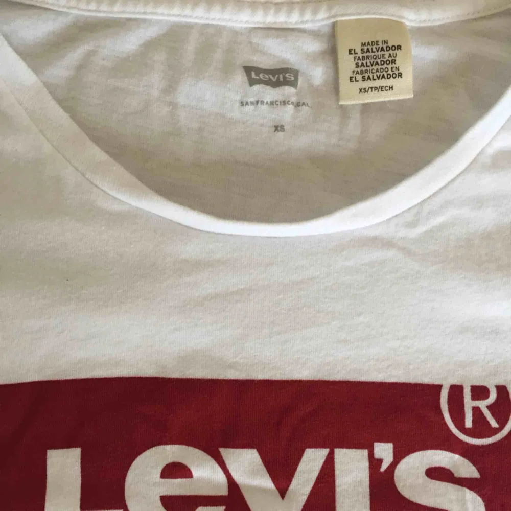 Basic vit Levi’s t-shirt, storlek XS. Längden av t-shirten går ner till under höfterna. > ALLA KLÄDERSOM KÖPS, TVÄTTAS OCH STRYKS INNAN SÄNDNING.. T-shirts.
