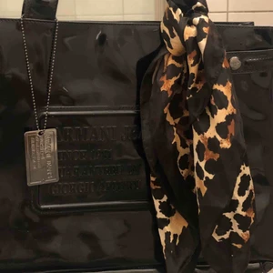  - Handväska från Armani Jeans har en svart lackad yttre präglad med Armani jeans logotyp och en matchande metallbricka. En magnetlås visar en textil inre med flera fack och en dragkedja I fint begagnat skick Nypris 1200:- Mitt pris 600:-