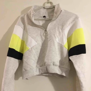  - Croppad neonsweatshirt med dragkedja. 