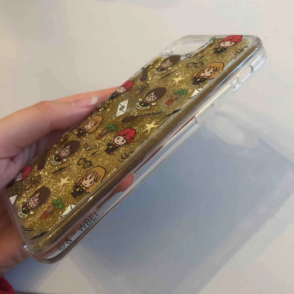 Mobilskal med Harry Potter-tryck och guldigt glitter som ”flyter” runt. Passar iPhone 6/7/8. Aldrig använt, endast testad. . Accessoarer.