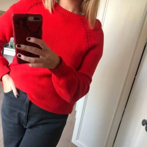  - Röd stickad tröja med sydda detaljer på armar och axlar. 
