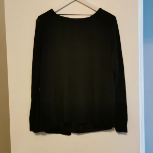 Tröja med 3 rosetter  - En genomskinlig tröja med ett innertyg som är i silke. Och 3 rosetter med slits på baksidan 