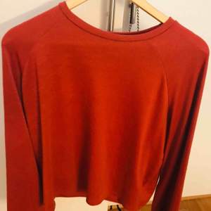 En röd/orange tröja med utsvängda armar. Aldrig använd. Nypris ca 300  Köpare står för frakt