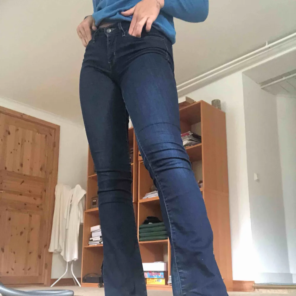 Ett par mörkblå bootcut jeans från Levis, jag har själv gjort slitsen där nere. De är också lite slitna mellan låren, som ni kan se på bild tre. Köptes för ca 1000kr.. Jeans & Byxor.