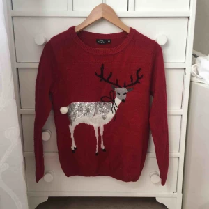  - Stickad jultröja med ren på. Svansen är en liten boll. 