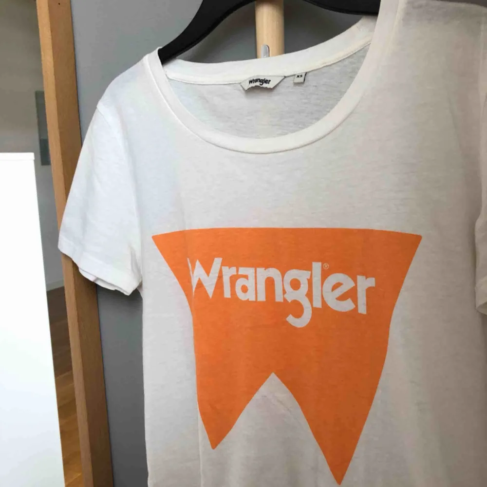Vit T-shirt med orange logga från wrangler. Storlek XS. Endast använd 2 ggr🧡🧡. T-shirts.