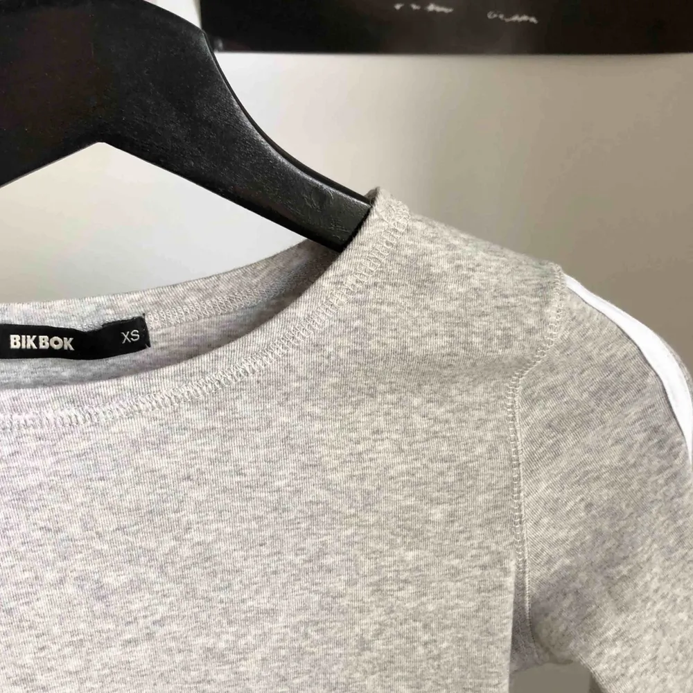 En grå långärmad tröja med två vita räder på ärmarna! Superskönt material, använd två gånger! 💕 Gratis frakt. T-shirts.