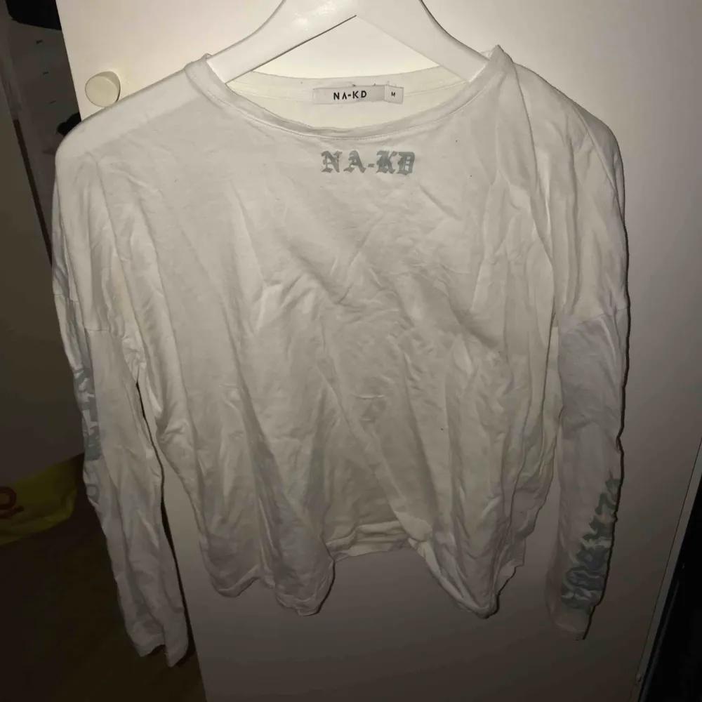 Kortare tröja från NAKD, med tryck vid urringningen samt armar i silver/reflex, möts upp i Uppsala. Kan frakta, köpare står för frakten . Toppar.