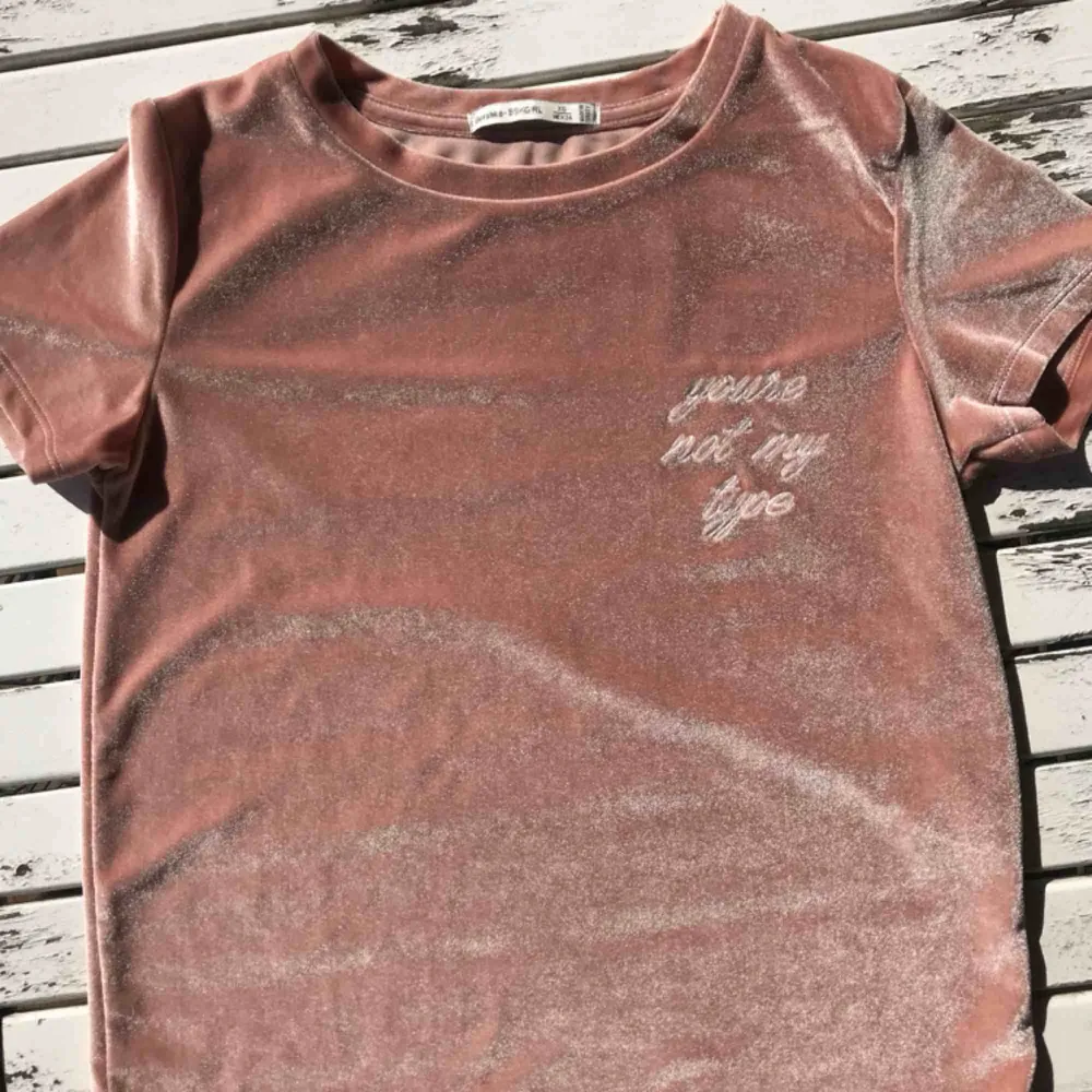 Snygg sammets t-shirt från berskha. Står ”You’re not My type” på bröstet. Glittrigt rosa (ser mörk ut på bilder vilket den inte är). Passar storlekar mellan Xs-s. 91% polyester 9% elastan. T-shirts.