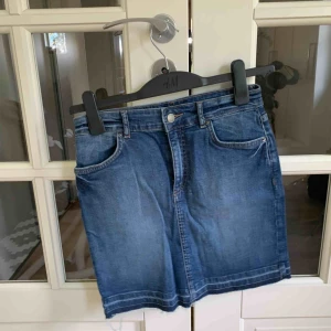  - Stretchig jeansskjol med slitningar längst ner. Använd 1 gång. Frakt tillkommer