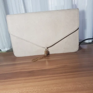  - Kuvertväska från ASOS med rektangulär form och guldfärgad tofs. Färgen är ljusrosa eller gräddvit. Höjd 17cm, bredd 28cm. Köpt för två månader sen och använd bara en gång för balen. Kostade 230 kr men säljer för 180kr fast priset kan diskuteras. Säljer för att det inte kommer till användning.💓💓