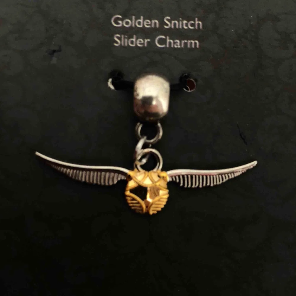 Oanvänd berlock föreställande en golden snitch från Harry Potter-museet i London.. Accessoarer.