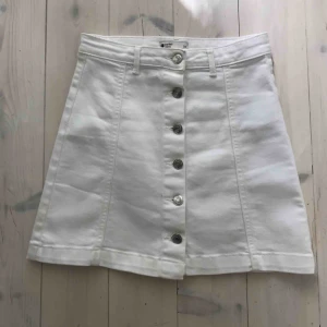  - Trendig kort vit jeanskjol. Triangelform med silvriga knappar. Knappt använd👍