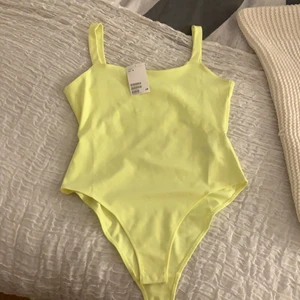 Neon body - Säljer denna neon bodyn ifrån hm. Den är aldrig använd och prislappen sitter kvar. Köparen står för frakten🤍