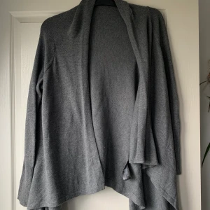 Kofta  - En grå fin kofta från Hm! Lite längre framtill! Fint skick. Näst intill aldrig använd! Hör av er vid frågor eller fler bilder✨