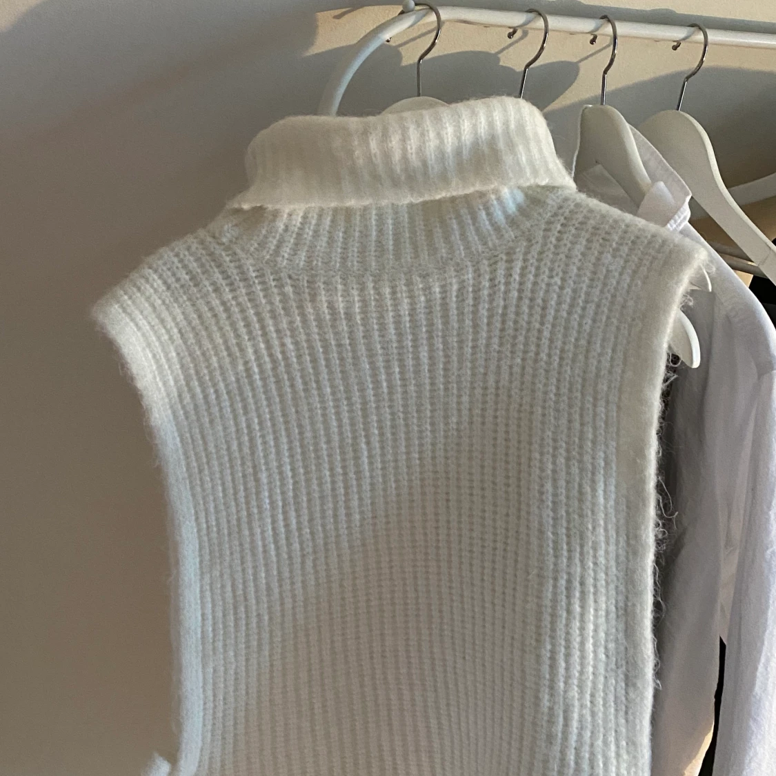 Stickad väst med rosett