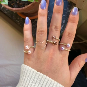 Ringar - Handgjorda ringar i rostfri guldfärgad metall, finns pärlor i lila, ljusrosa och brun. Lättjusterbara storleksmässigt. Frakt kostar 11 kr 🥰