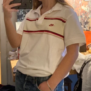 Nike piké  - Skitsnygg pikétröja från Nike i storlek M med coola röda och beiga detaljer runt hela tröjan. (Jag passar i storlek XS-S och är 160 cm) köparen står för frakt!