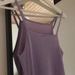 lila klänning från weekday  - Lila ribbad och skimrig klänning från weekday. Går till mitten av låret och är något tajt och figursydd. Aldrig använd. Lite halterneckkännsla. Storlek xs men passar även s.