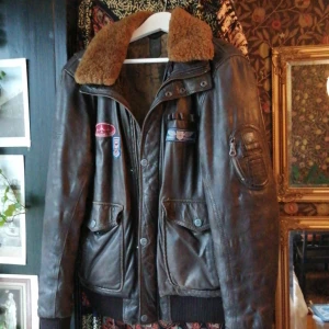 Läderjacka  - Min fina läderjacka som säljs då den inte är av användning. Äkta läder med coola air force detaljer och ull runt kragen. Sitter oversize på mig som är M men den passar alla storlekar! Är ca 3 år gammal och har inget slitage. Köpte den för 1100kr✈️🧡🤎