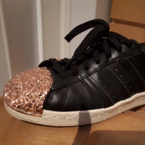  - Adidas Superstar med guldglitter tå.  Storlek 36,5 I bra skick.