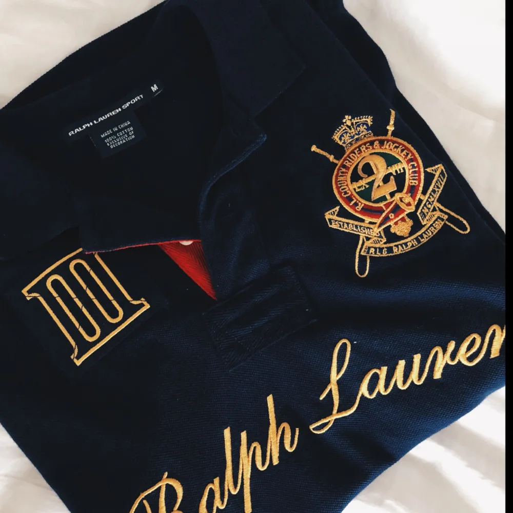 Ralph Lauren sport piké tröja i färgen mörkblå med guld detaljer. Inköpt i USA. Storlek M men skulle vilja säga att den sitter som en S. Jag står för frakten på detta plagg🎀. T-shirts.