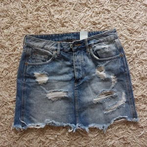  - Jeanskjol med slitningar. Från H&M, storlek 36.