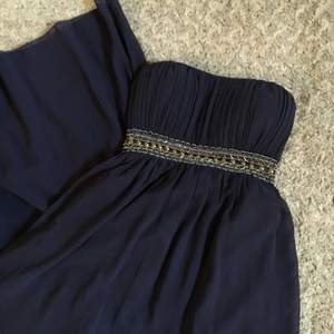 Använd en gång under bal. Marinblå långklänning med lite strass! Insydd i ryggen men går enkelt att sprätta upp för större storlek om så önskas. 