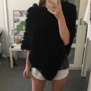  - Svart poncho i kaninpäls. I nyskick. Är verkligen supervarm för kalla kvällar eller höst.