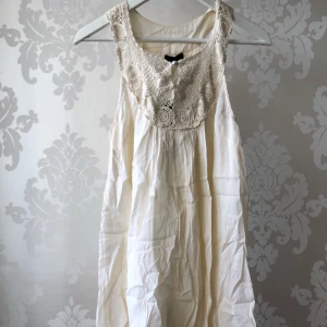  - Vitklänning med spetsdetaljer. Oanvänd med etikett på. Ordinarie pris 399kr. 85cm från axel