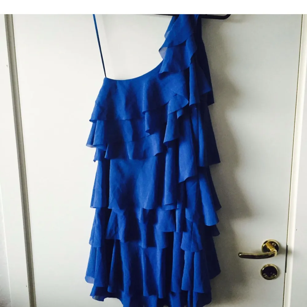 Ny! Blå klänning oanvänd med volanger. Inköpt från H&M i storlek 36. Frakt: 62kr. Klänningar.