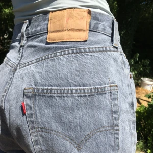  - Klassiska Levi’s 501-or, något alla borde ha i garderoben! Dessa är i grått. Sitter väldigt löst på mig som har 36 och passar bättre en 38/40. Lite slitna vid knappen - se bild tre. Tyg i bra skick. 