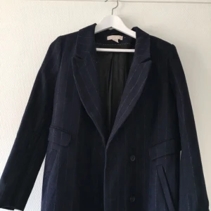  - Lång kappa som går ner till vaderna. Marinblå med ränder. Köparen står för frakt. 