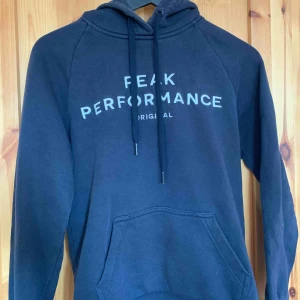  - Marinblå Peak Performance, en liiiten fläck på baksidan av ärmen som knappt syns. Köparen står för frakten. 