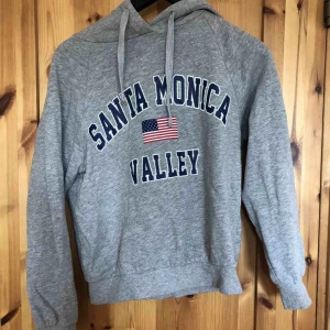  - Grå hoodie med tryck, bra skick. Köparen står för frakten.