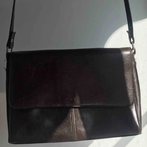  - En brun väska köpt på secondhand. 