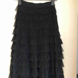  - Svart vadlång kjol med volanger i storlek 34. Fint skick. Frakt tillkommer. 