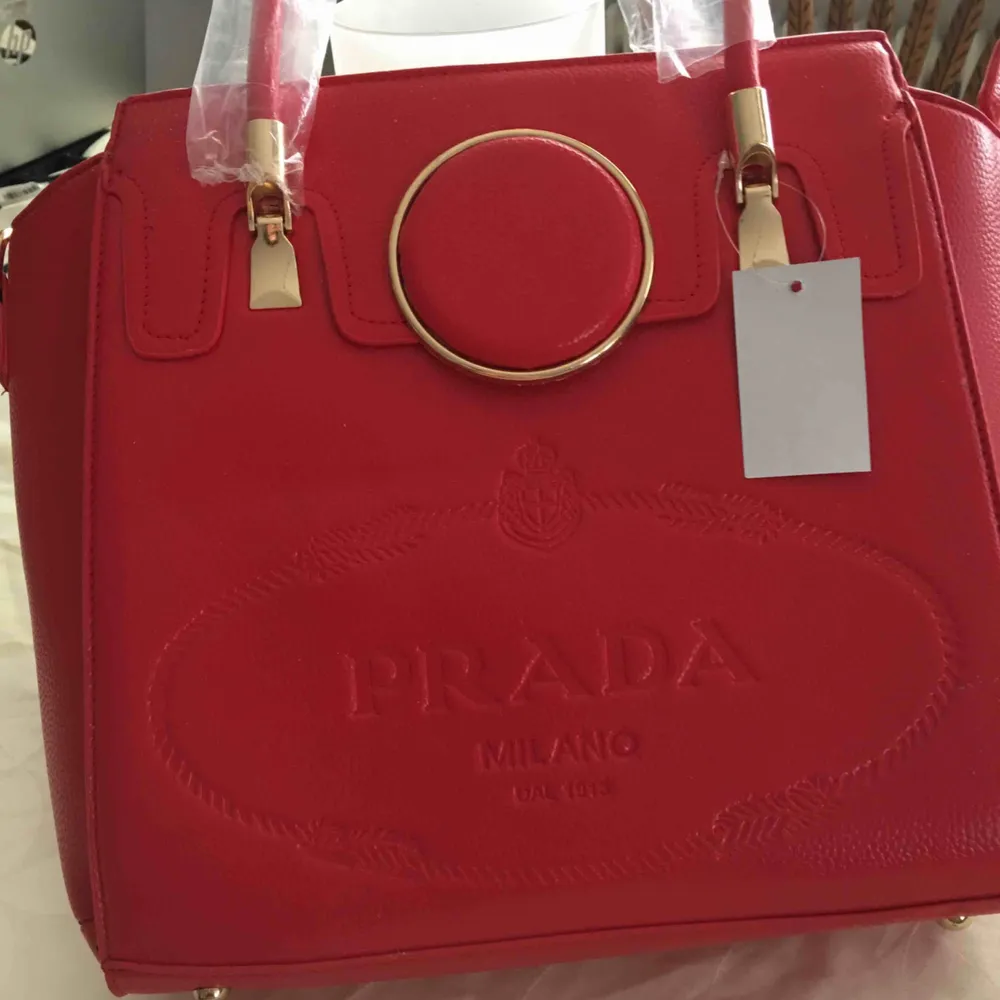 Jätte fin oäkta röd prada handväska som passar allt till o med finns plats för liten laptop . Väskor.