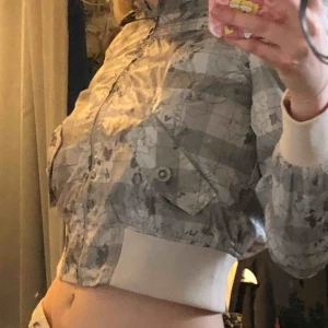  - Jacka/vindjacka som sitter cropat med blommor på, luvan går att ta av. Frakt tillkommer💙