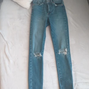 Blåa jeans med hål - Jättefina stretchiga jeans, lite hårdare stretch  material. Sitter jättebra, säljer dock pga att dom ibte kommer till använding 